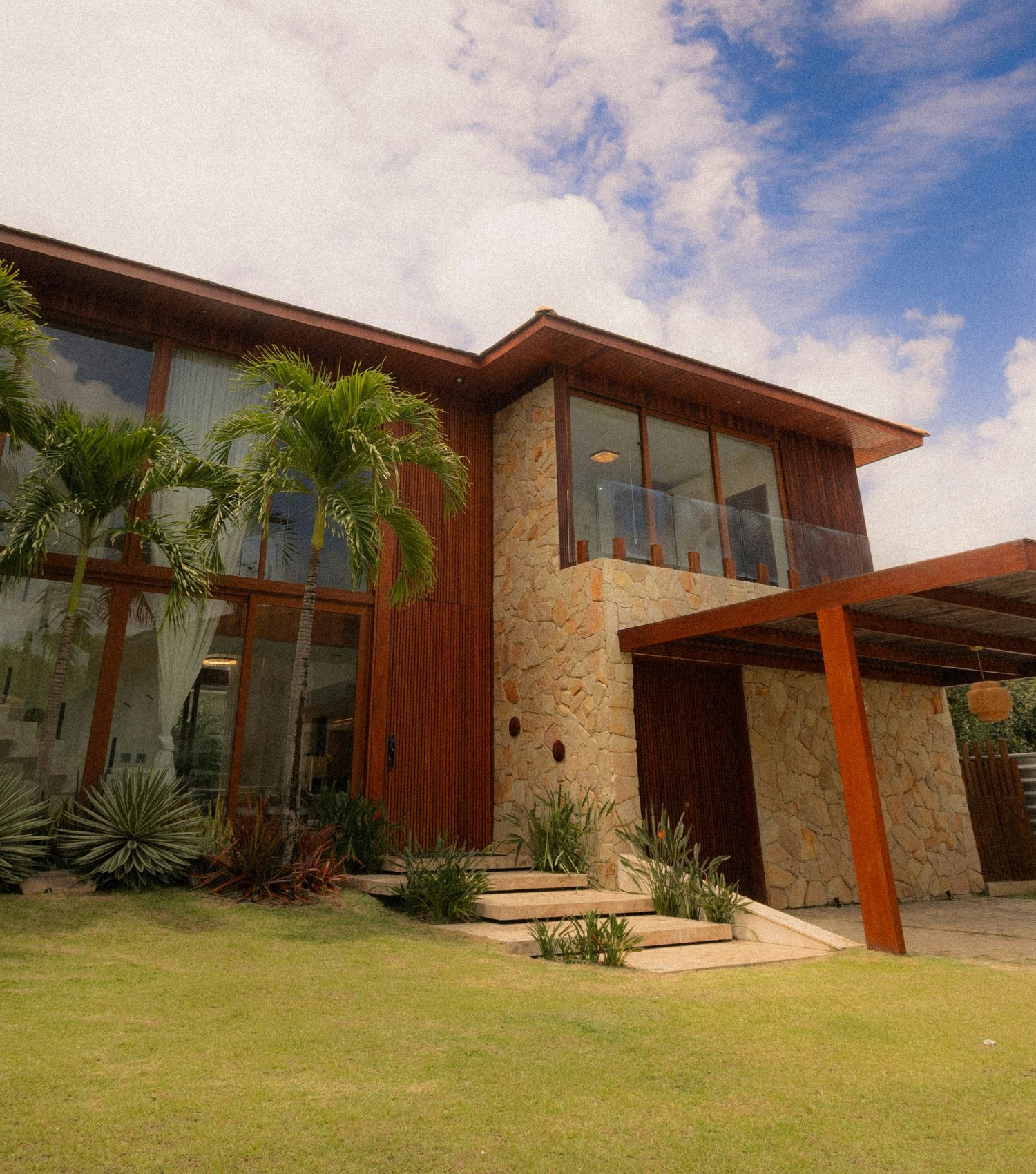 Professionally photographed modern detached home with a landscaped lawn, warm timber details and a covered entrance; representative photography for the RentHub rental search experience.
