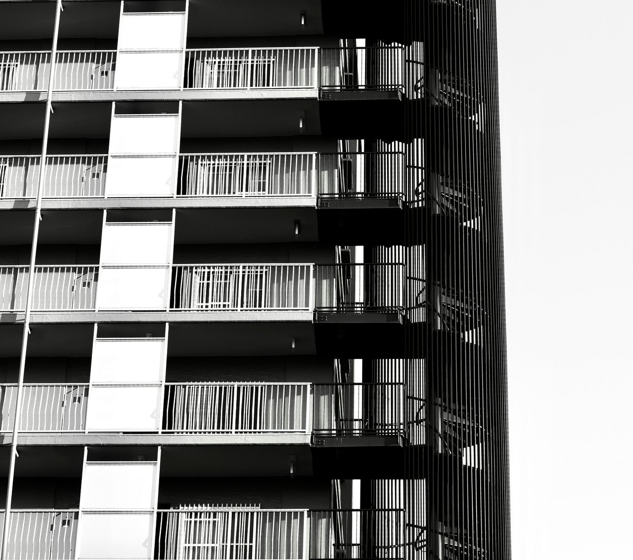 Professionally photographed multi-level residential building with repeated balconies and visible access routes, reinforcing the importance of inspecting a property and its surroundings.