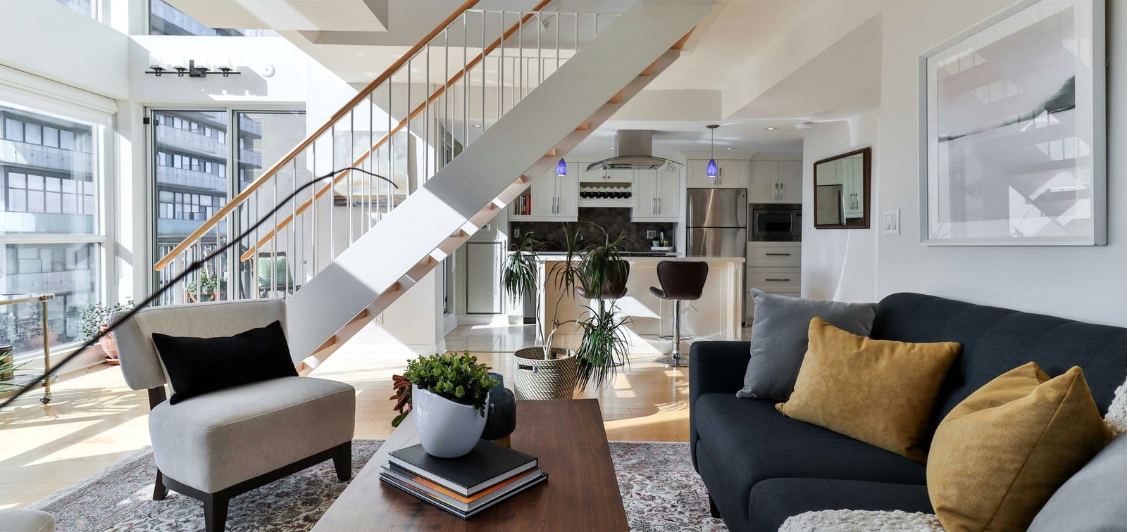 Professionally photographed contemporary living space with a staircase, natural light and carefully arranged furniture, representing the quality and clarity RentHub wants renters to see.