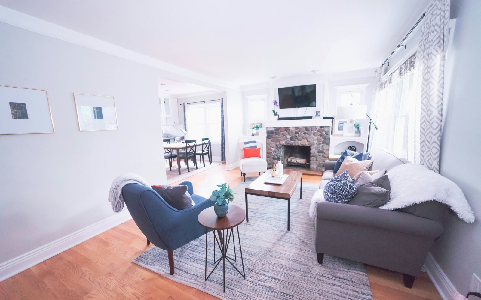 Professional photograph of a renovated living room with grey seating, pale walls and an adjoining dining area; representative demo image for the Ahodwo chamber-and-hall unit Gallery image 1 of 5 for Renovated Chamber and Hall in Ahodwo.
