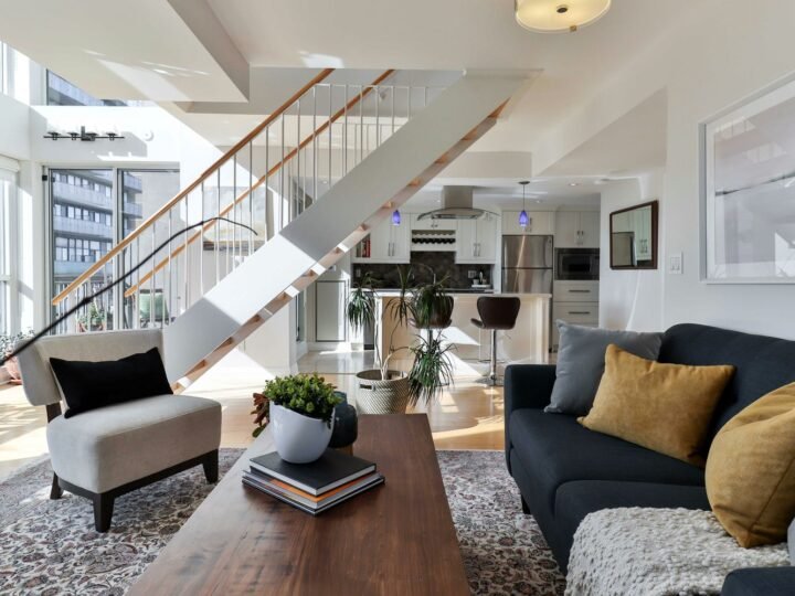 Professional photograph of an executive living room with staircase, balcony windows and contemporary furniture; representative demo image for the Cantonments townhouse Gallery image 1 of 5 for Executive 4-Bedroom Townhouse in Cantonments.