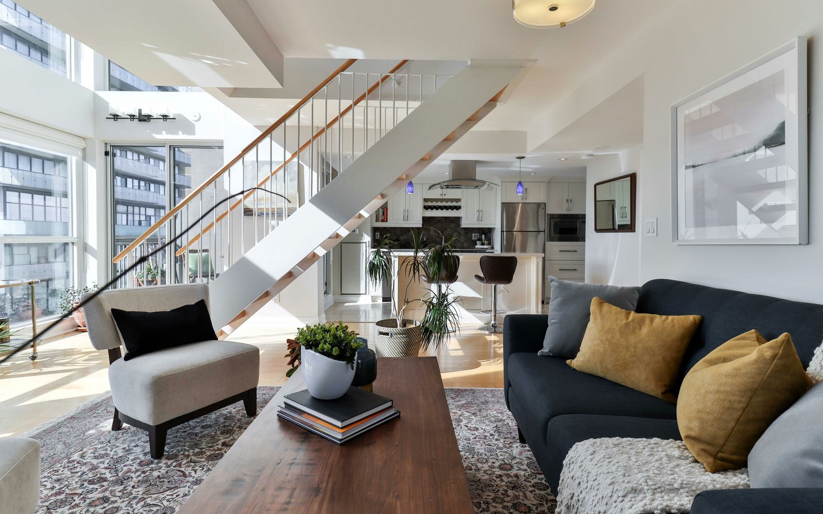 Professional photograph of an executive living room with staircase, balcony windows and contemporary furniture; representative demo image for the Cantonments townhouse Gallery image 1 of 5 for Executive 4-Bedroom Townhouse in Cantonments.