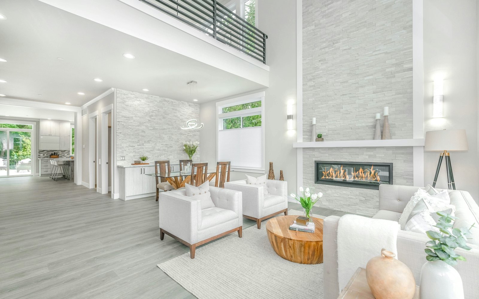 Professional photograph of a bright open-plan modern apartment with white seating, a fireplace and large windows; representative demo image for the East Legon apartment Gallery image 1 of 5 for Modern 2-Bedroom Apartment in East Legon.