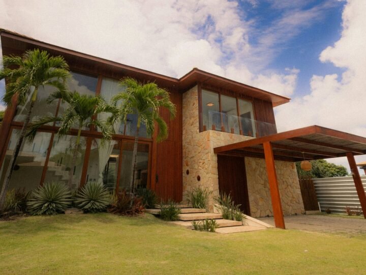 Professional exterior photograph of a spacious contemporary two-storey house with lawn, palms and a covered driveway; representative demo image for the Lakeside family house Gallery image 1 of 5 for Spacious 3-Bedroom Family House at Lakeside Estate.