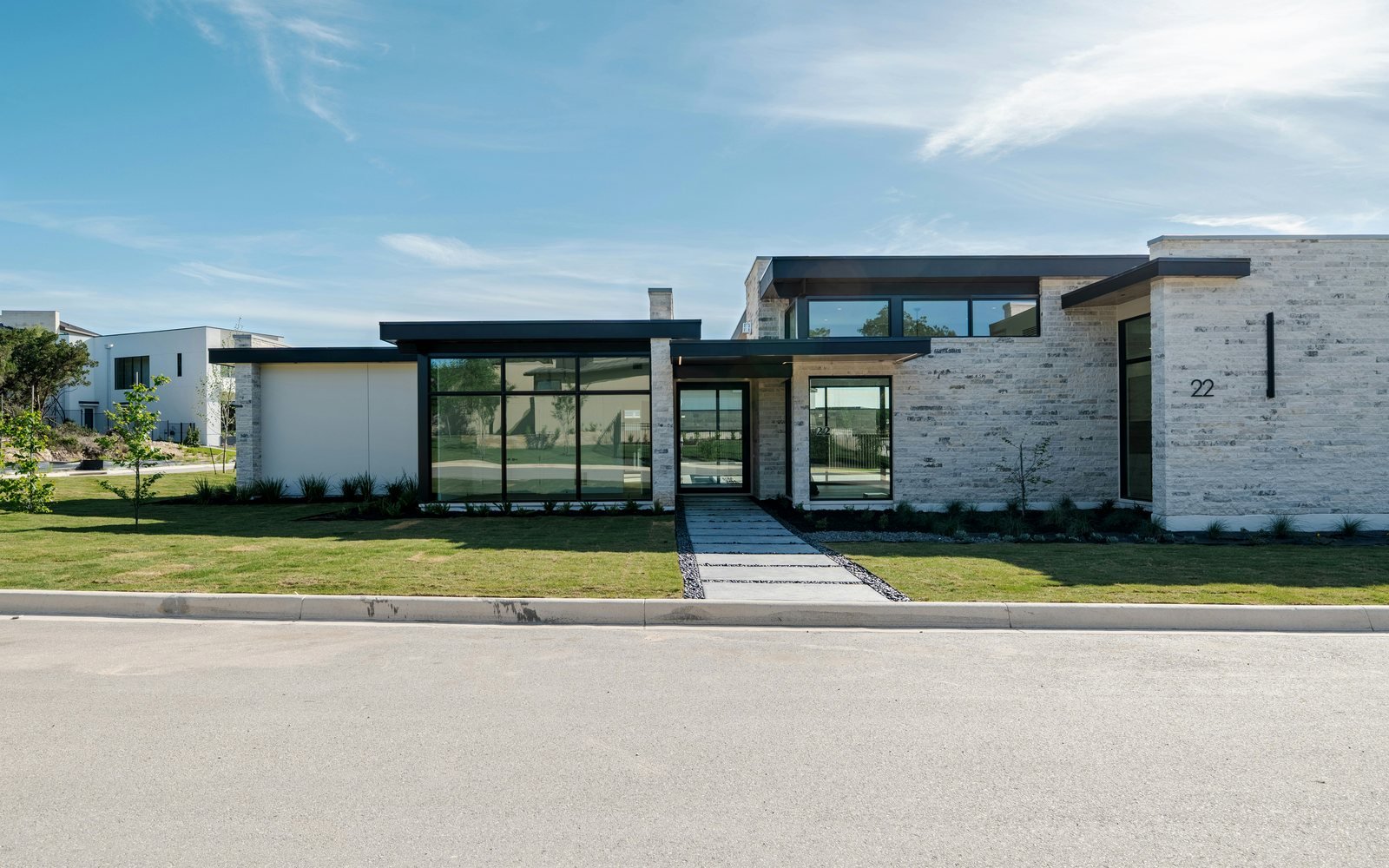 Professional exterior photograph of a modern gated single-storey home with stone details, a broad entrance and landscaped lawn; representative demo image for the Tema home Gallery image 1 of 5 for Gated 3-Bedroom Home in Tema Community 25.